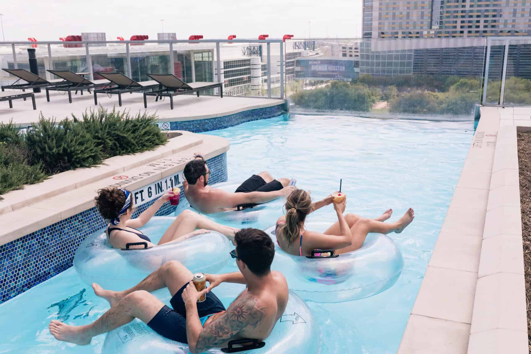 Four people floating in water on tubes.