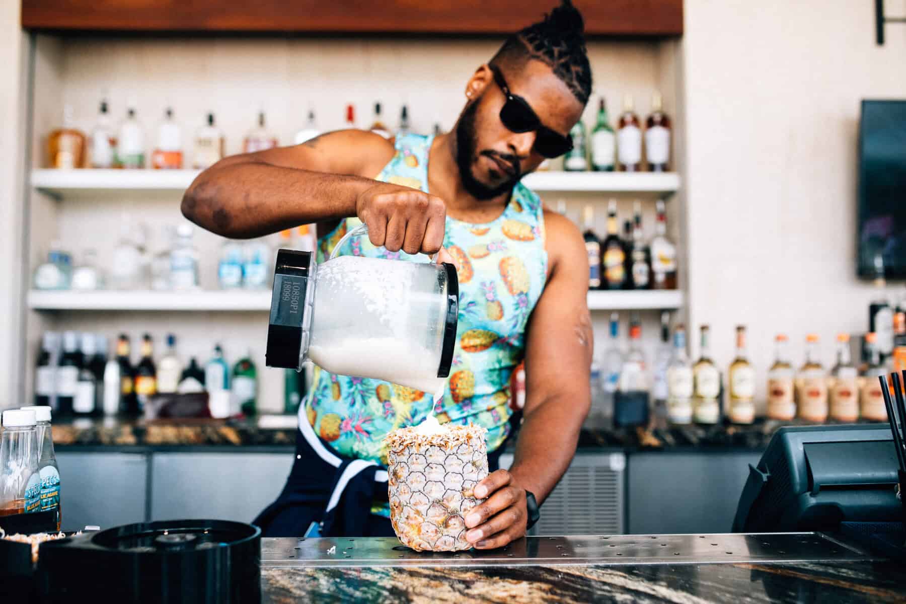 A man pouring a drink into a pineapple