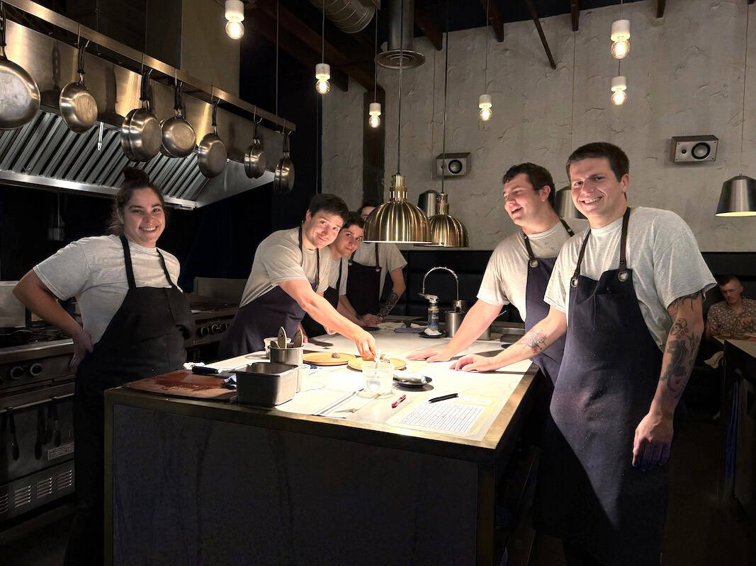 Chefs preparing dishes in the open kitchen at Michelin-starred Restaurant ARVI.