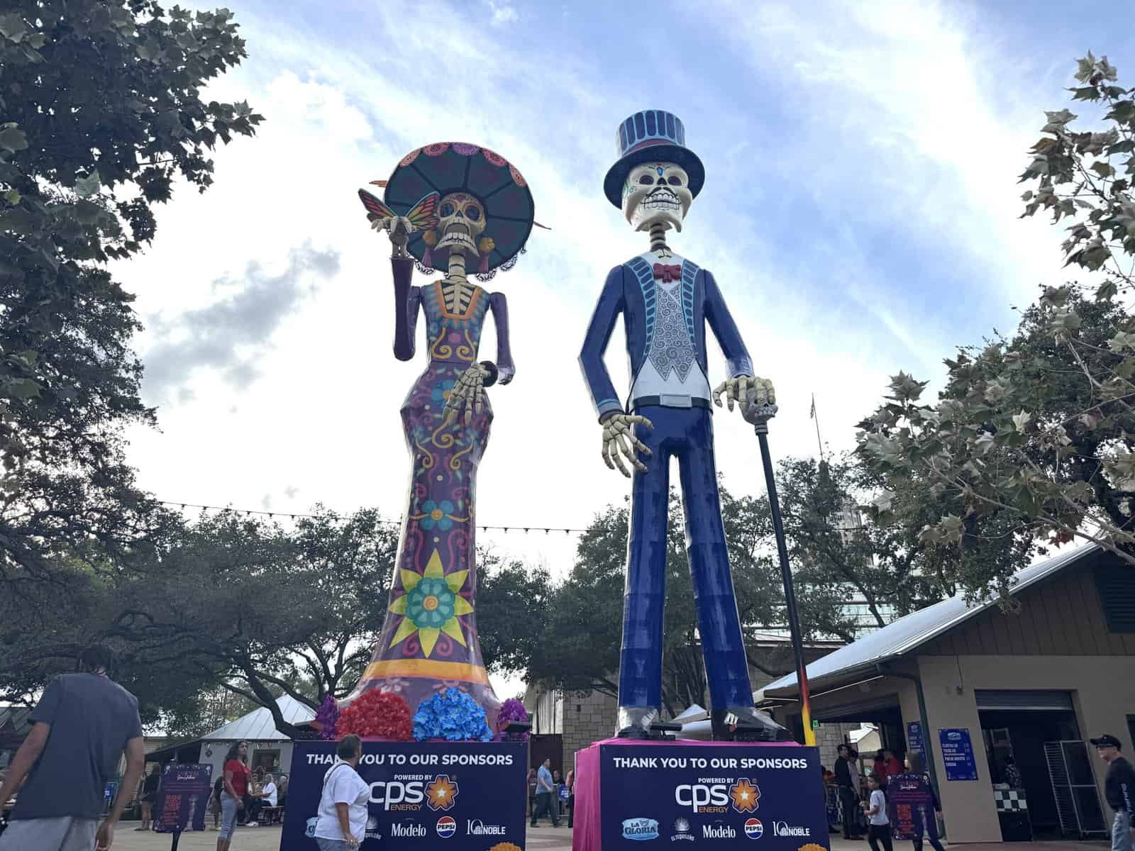 A colorful, decorated catrin and catrina pair of skeletons displayed in historic La Villita.