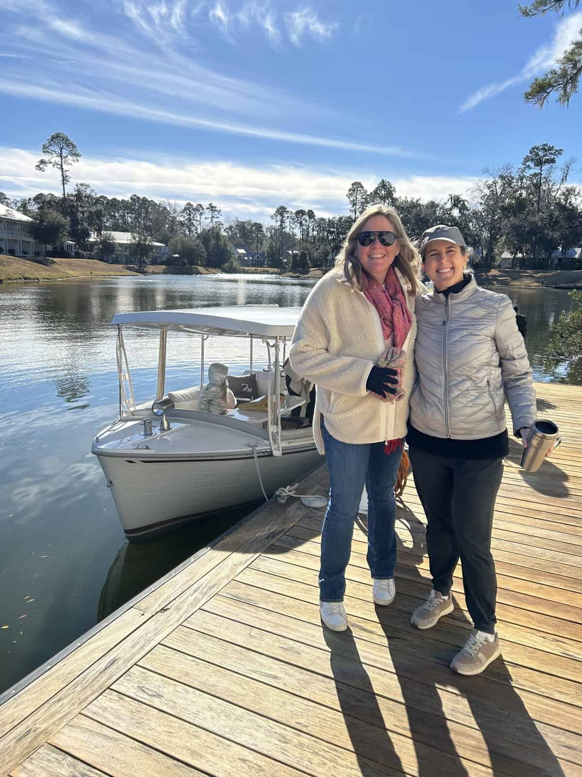 Two women standing on a dock with a boat at Montage Palmetto Bluff.