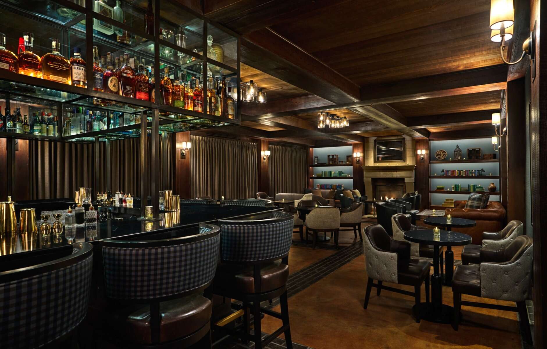 Speakeasy interior with leather chairs, bourbon bar, and bookshelves at Hush.