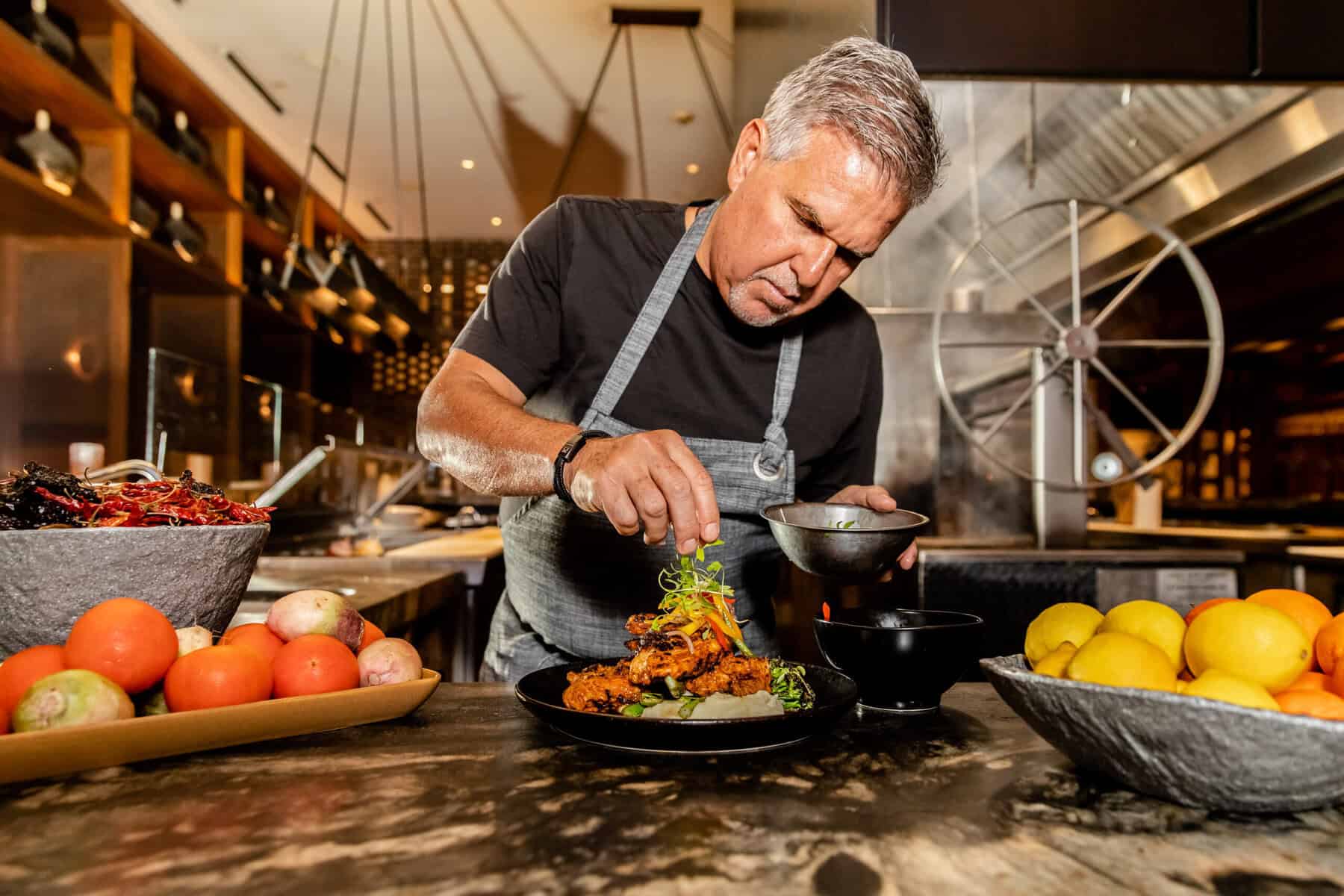 Chef Richard Sandoval garnishing a plate.