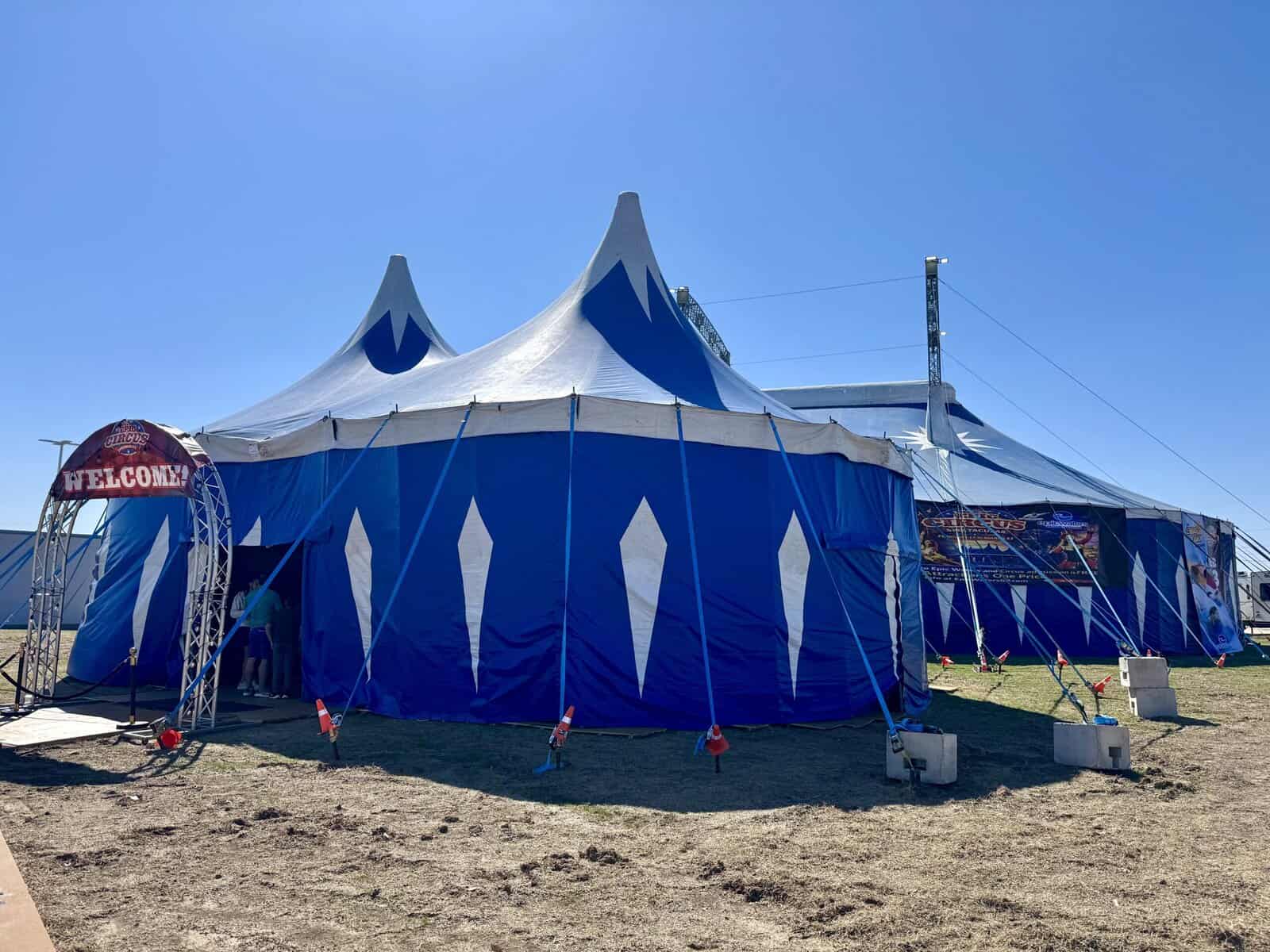 Blue circus tent with decorative large white diamonds and a welcome sign over the entrance.