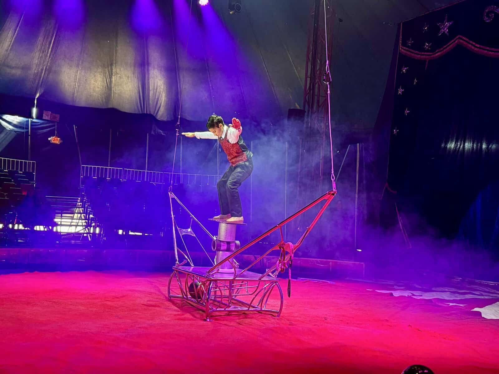 Boy balances on three cylinders.