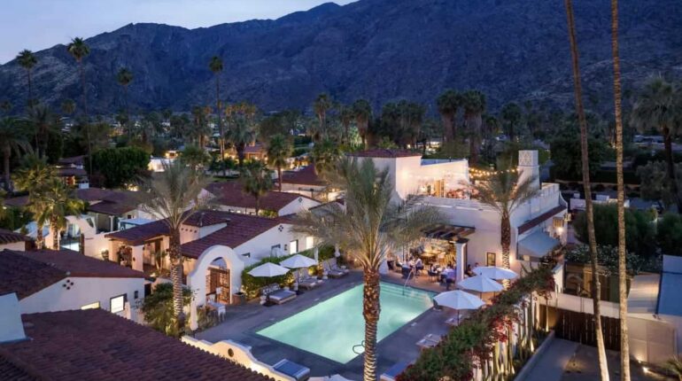 Aerial view of La Serena Villas at blue hour with pool illuminated.