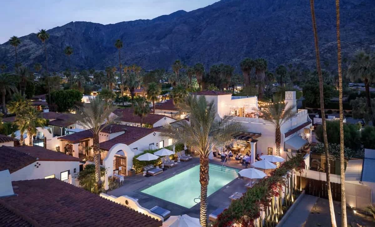 Aerial view of La Serena Villas at blue hour with pool illuminated.