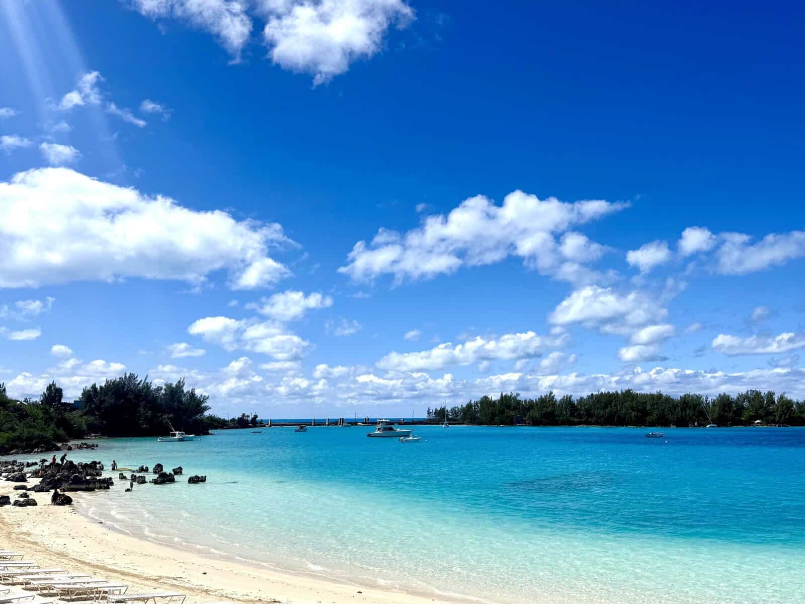 Shallow ocean water with varying shades of blue and small boats