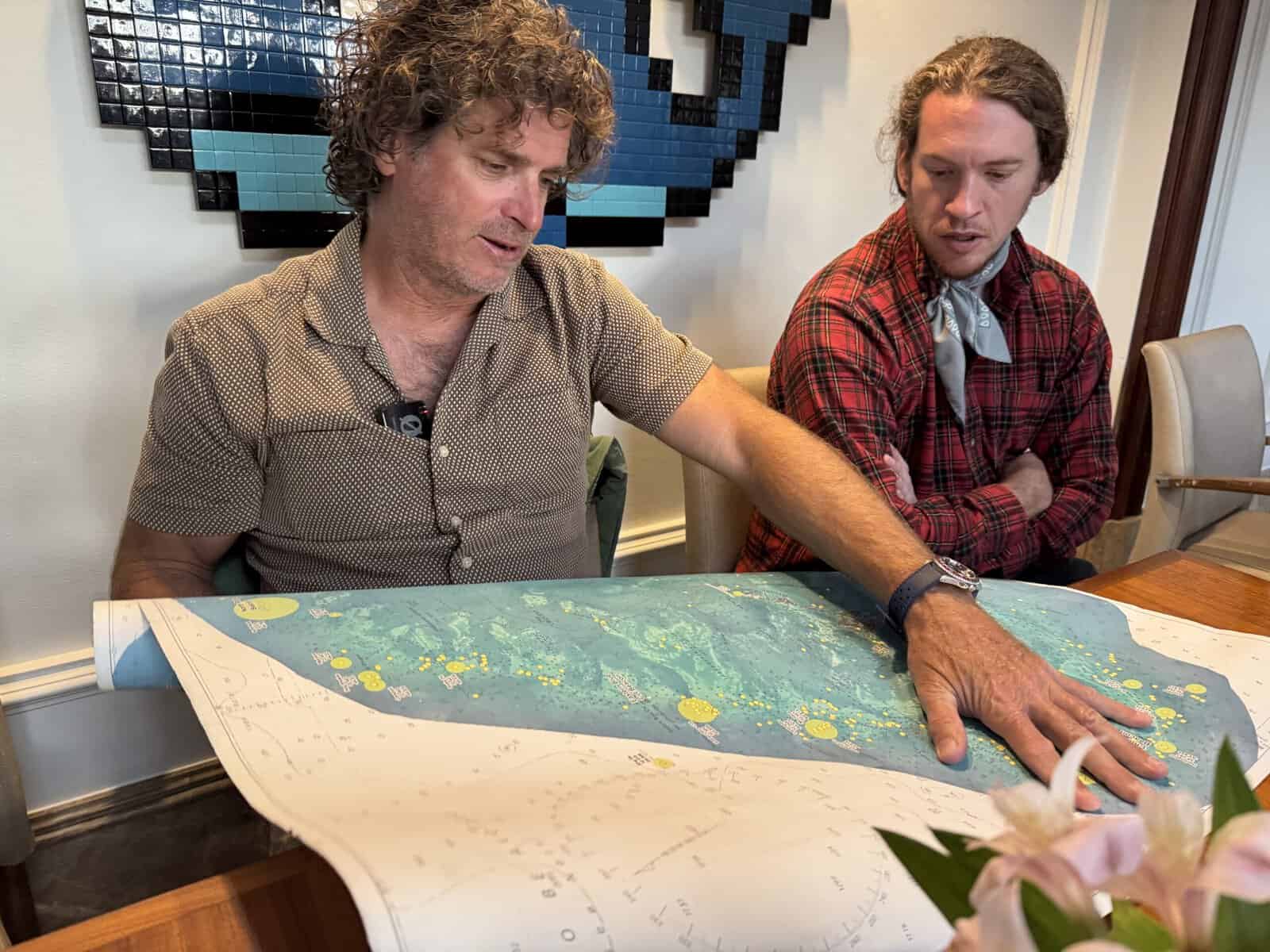 Two men look at a map of Bermuda