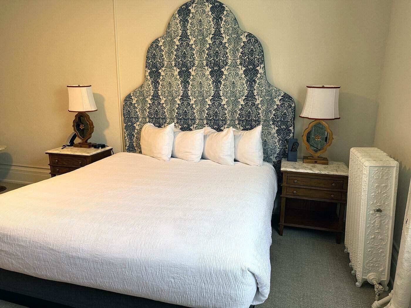 Hotel Colorado king bed, night stands and vintage radiator.